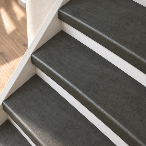 beton grijs traprenovatie, dichte trap met witte stootborden, detail schuin van boven